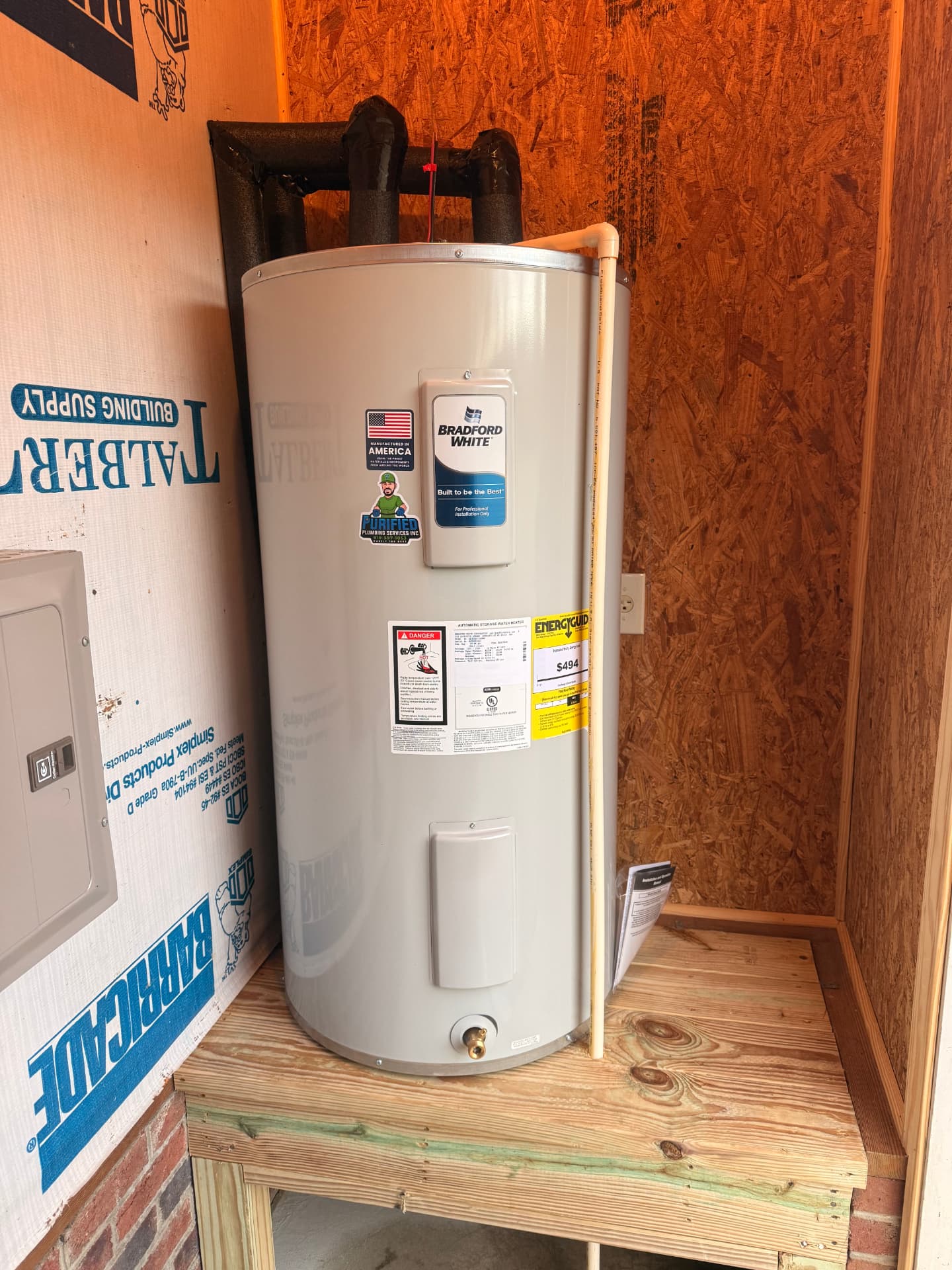 New Bradford White electric water heater set on a built platform