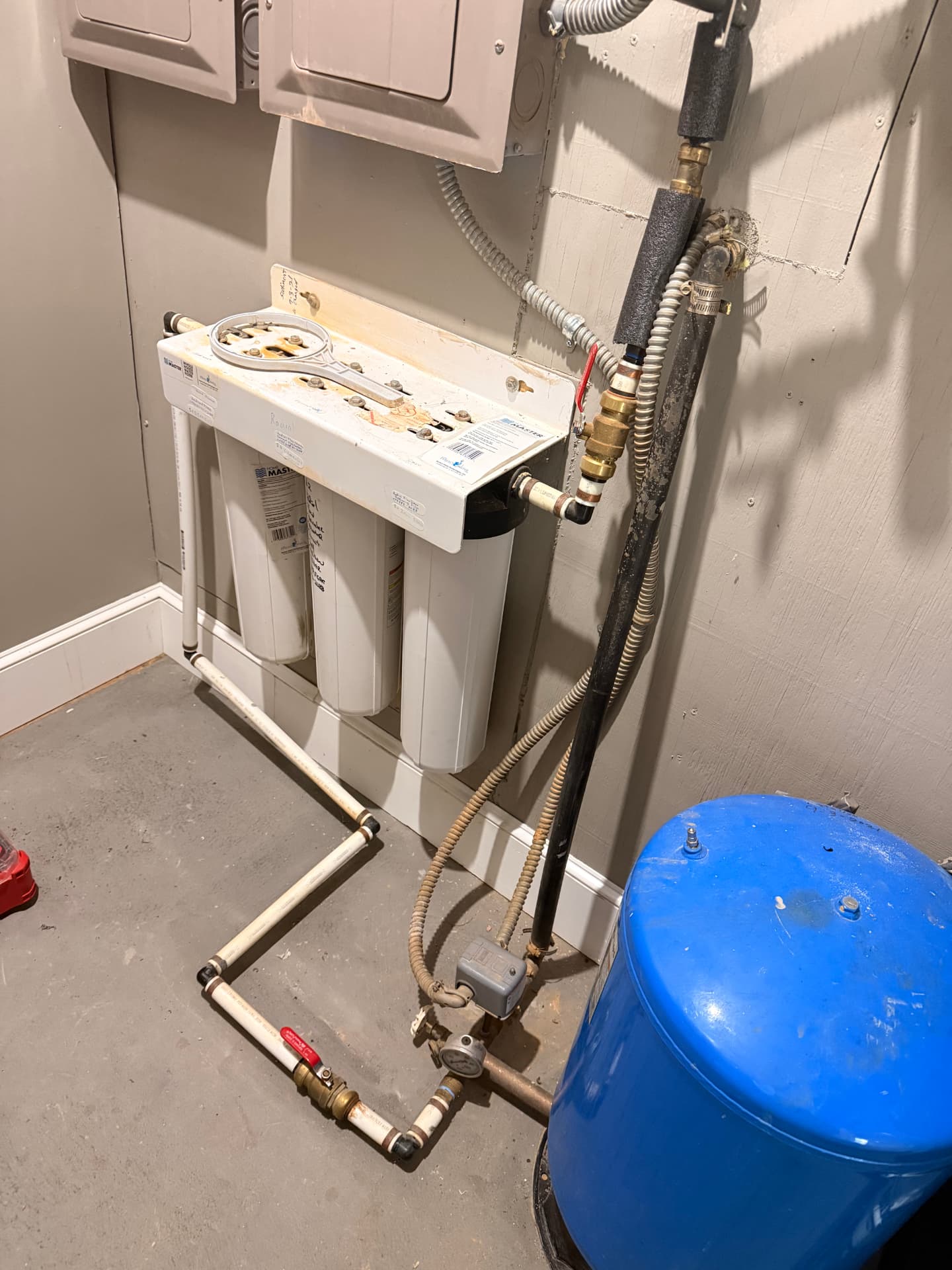 Whole-house filter and pressure tank set up in a basement
