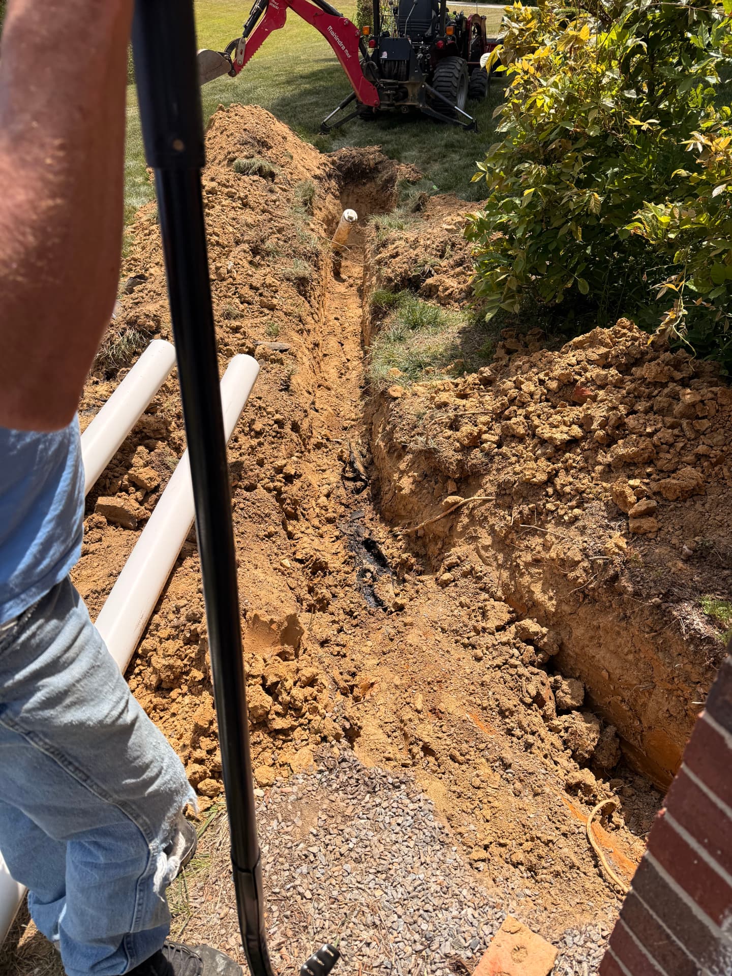 Water service trench dug beside the house with the mini excavator