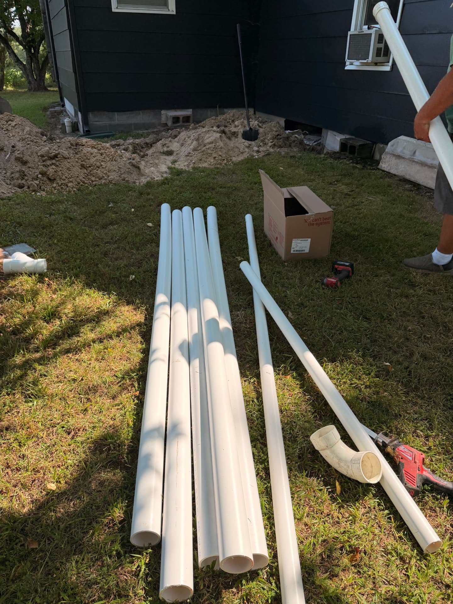 PVC sewer pipe and fittings staged for installation